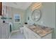 Bathroom with granite countertop, walk-in shower, and teal accents at 11247 Euler Ave, Englewood, FL 34224