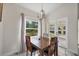 Bright dining area with wooden table and chairs, featuring a view to the backyard at 11247 Euler Ave, Englewood, FL 34224