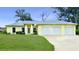 Bright yellow house with three-car garage and well-manicured lawn at 11247 Euler Ave, Englewood, FL 34224