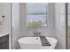 Relaxing bathroom featuring a freestanding bathtub and a large window at 1169 Boundary Blvd, Rotonda West, FL 33947