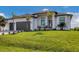 Modern two-car garage home with a lush lawn at 1169 Boundary Blvd, Rotonda West, FL 33947