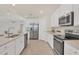 Modern kitchen with white cabinets, stainless steel appliances, and an island at 12580 Ghiberti Cir # 101, Venice, FL 34293