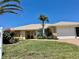 Single-story home with a two-car garage and mature landscaping at 145 Bunker Rd, Rotonda West, FL 33947