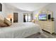 Comfortable bedroom with a queen-size bed, dresser, and access to balcony at 1551 Beach Rd # 205, Englewood, FL 34223