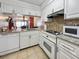 White kitchen with granite countertops, stainless steel appliances and a view into the dining area at 1551 Beach Rd # 205, Englewood, FL 34223