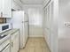 White kitchen with granite countertops, stainless steel appliances, and adjacent pantry at 1551 Beach Rd # 205, Englewood, FL 34223