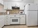 White kitchen with granite countertops and stainless steel appliances at 1551 Beach Rd # 205, Englewood, FL 34223