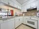 White kitchen with granite countertops, stainless steel appliances, and view to dining area at 1551 Beach Rd # 205, Englewood, FL 34223