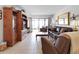Spacious living room featuring a leather sofa, two armchairs, and a large wooden entertainment center at 1551 Beach Rd # 205, Englewood, FL 34223