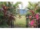 Charming backyard access through a black metal gate at 170 Antilla Dr, Rotonda West, FL 33947