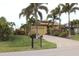 Tan house with palm trees, landscaped yard, and a paved driveway at 170 Antilla Dr, Rotonda West, FL 33947