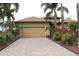 Tan house with palm trees and a landscaped yard at 170 Antilla Dr, Rotonda West, FL 33947