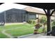 View from under a covered patio showing a house with a screened enclosure and landscaping at 170 Antilla Dr, Rotonda West, FL 33947