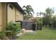 Backyard view of a tan house with AC unit, storage shed, and green lawn at 170 Antilla Dr, Rotonda West, FL 33947