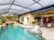 Inviting pool and patio with waterfall, outdoor kitchen and seating at 170 Antilla Dr, Rotonda West, FL 33947