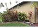 Landscaped side yard with tropical plants and a fence at 170 Antilla Dr, Rotonda West, FL 33947