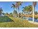 Grass yard with canal, palm trees, and a view of neighboring homes at 197 Bunker Rd, Rotonda West, FL 33947