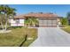 Single-story home with brown roof, attached garage, and palm trees at 197 Bunker Rd, Rotonda West, FL 33947