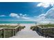 Wooden staircase leads to a beautiful beach with blue water and white sand at 221 E Wentworth St, Englewood, FL 34223
