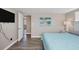Bright bedroom with a light blue comforter and hardwood floors at 221 E Wentworth St, Englewood, FL 34223