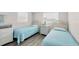 Twin bedroom with white wicker headboards and light blue bedding at 221 E Wentworth St, Englewood, FL 34223