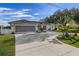 House exterior showcasing a two-car garage and palm trees at 249 Sportsman Rd, Rotonda West, FL 33947