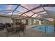 Inviting pool area with screened enclosure, patio furniture, and grill at 249 Sportsman Rd, Rotonda West, FL 33947