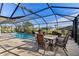 Inviting pool area with screened enclosure, patio furniture, and lush landscaping at 249 Sportsman Rd, Rotonda West, FL 33947