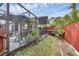Landscaped backyard with screened patio and red fence at 255 Boundary Blvd # 104, Rotonda West, FL 33947