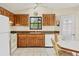 Kitchen with wood cabinets, white appliances, and granite countertops at 255 Boundary Blvd # 104, Rotonda West, FL 33947
