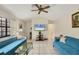 Living room with teal couches, TV, and ceiling fan at 255 Boundary Blvd # 104, Rotonda West, FL 33947