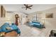 Living room with teal couches, glass coffee table, and ceiling fan at 255 Boundary Blvd # 104, Rotonda West, FL 33947