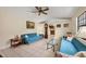 Living room with teal couches, glass coffee table, and ceiling fan at 255 Boundary Blvd # 104, Rotonda West, FL 33947
