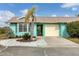 Charming teal home with a one-car garage and nicely landscaped front yard at 255 Boundary Blvd # 105, Rotonda West, FL 33947