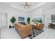 Open living room with brown leather couches, a large TV, and sliding doors to the lanai at 275 Broadmoor Ln, Rotonda West, FL 33947