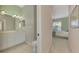 Double vanity bathroom with a toilet and view into bedroom at 2888 Myakka Creek Ct., Port Charlotte, FL 33953