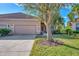 Tan house with three-car garage and mature landscaping at 2888 Myakka Creek Ct., Port Charlotte, FL 33953