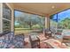 Relaxing screened porch with wicker furniture and view of backyard at 2888 Myakka Creek Ct., Port Charlotte, FL 33953