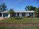 White ranch home with teal garage door and shutters at 320 Lasayette Ne Dr, Port Charlotte, FL 33952