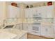 White kitchen features marble countertops and stainless steel appliances at 3283 Osprey Ln, Port Charlotte, FL 33953