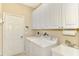 Bright laundry room, featuring white cabinets and a utility sink at 3283 Osprey Ln, Port Charlotte, FL 33953