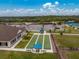 Aerial view of bocce ball courts, a clubhouse, and parking lot at 3310 Bay Ridge Way, Port Charlotte, FL 33953