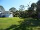 Spacious backyard with mature trees and lush landscaping at 380 Hoffer St, Port Charlotte, FL 33953