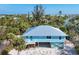 Aerial view of a light blue house with metal roof and tropical landscaping at 396 N Gulf Blvd, Placida, FL 33946
