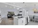 Modern kitchen with white cabinets, island with sink, and stainless steel appliances at 396 N Gulf Blvd, Placida, FL 33946