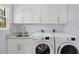 Laundry room with washer, dryer, and white cabinets at 396 N Gulf Blvd, Placida, FL 33946