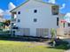 Rear exterior view of the condo with multiple balconies, yard and fire hydrant at 5031 N Beach Rd # 116, Englewood, FL 34223