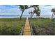 Picturesque boardwalk leading through lush vegetation to the tranquil waters of the ocean at 5031 N Beach Rd # 116, Englewood, FL 34223