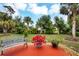 Landscaped backyard with a patio, bench, and lush greenery at 6256 Pennell St, Englewood, FL 34224
