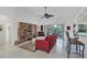 Living room with red couch, built-in shelving, and patio access at 6256 Pennell St, Englewood, FL 34224